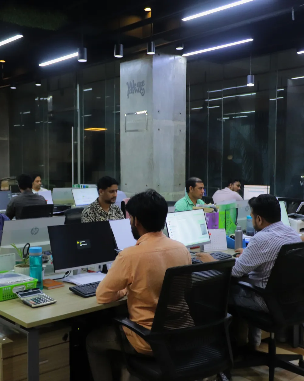 Staff working at desks in a glass partitioned office