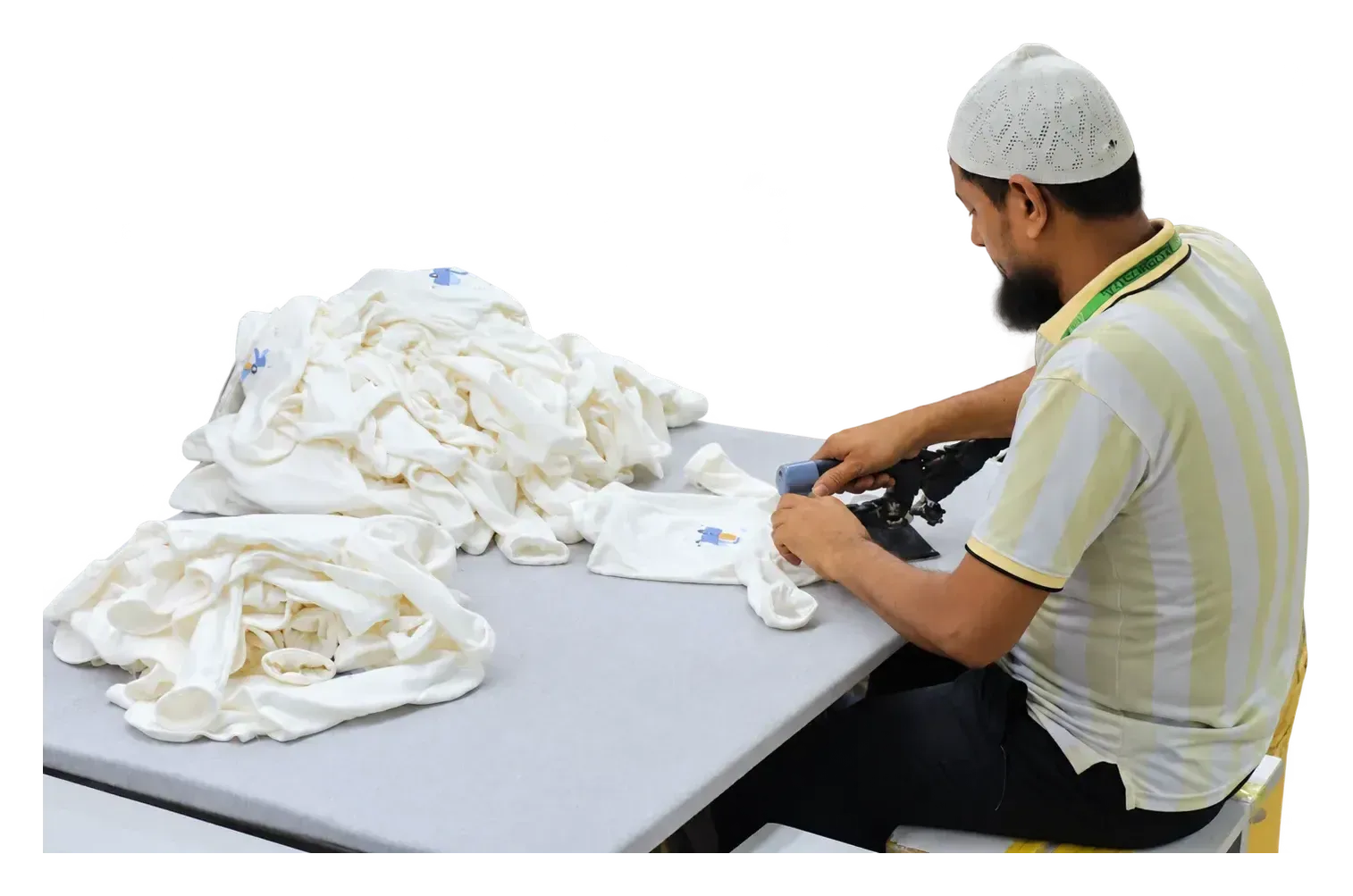 A worker pressing a printed white garment at a finishing table